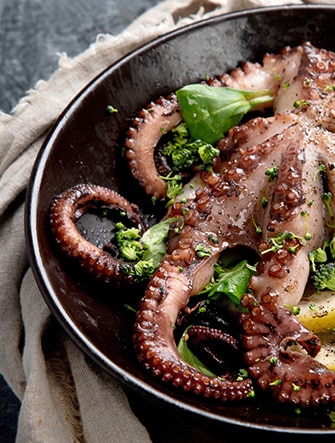 Tintenfisch mit Gemüse am Servierteller.