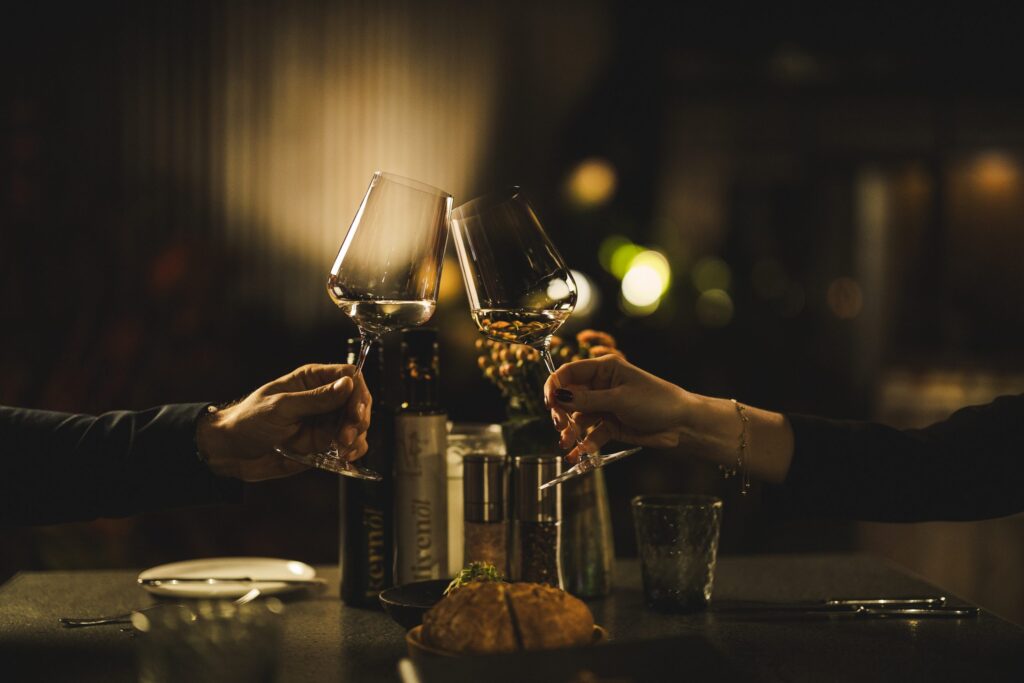 Stilvoll das Glas mit Krispel Wein erheben und anstoßen